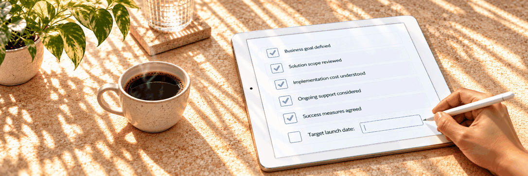 Tablet checklist on a cork desk with coffee; hand with stylus on Target launch date after checking business goal, solution scope, cost, support, and success measures